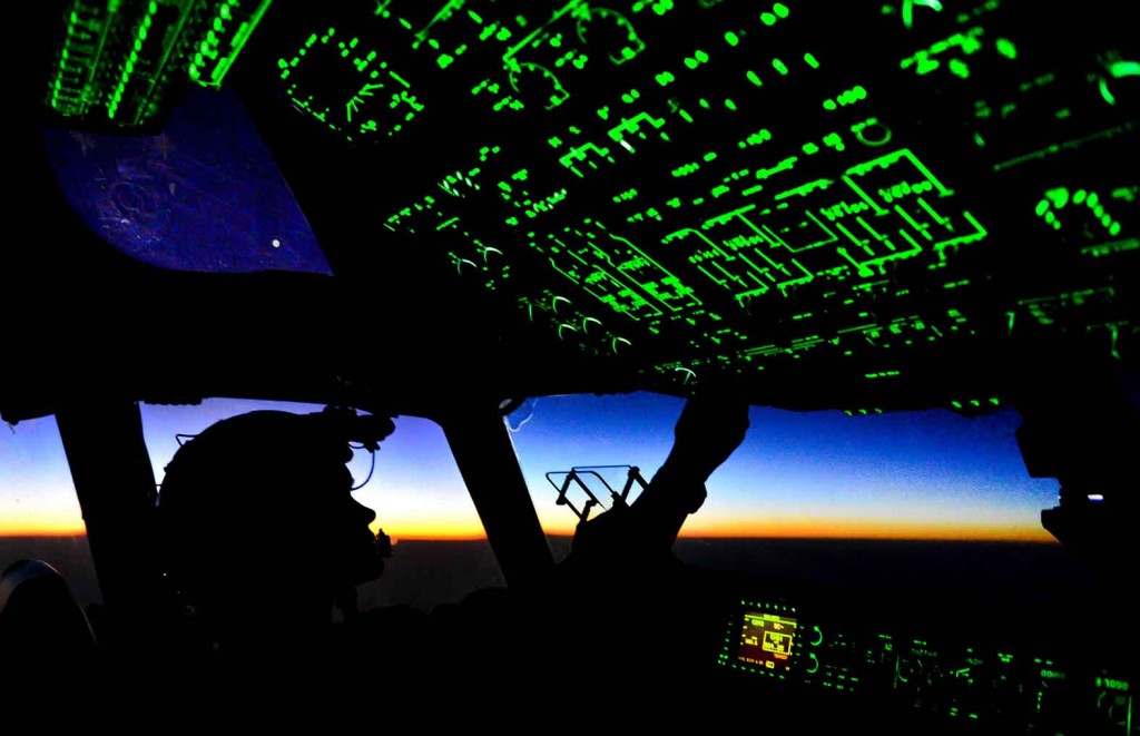 Capt. Erica Stooksbury 816th Expeditionary Airlift Squadron, C-17 Globemaster III pilot, adjusts the cockpit lighting controls as the sun rises after a humanitarian airdrop mission over Amirli, Iraq, Aug. 31, 2014. The two C-17s dropped 79 container delivery system bundles of fresh drinking water totaling 7,513 gallons. In addition, the two U.S. C-130s aircraft dropped 30 bundles totaling 3,032 gallons of fresh drinking water and 7,056 meals ready to eat. (U.S. Air Force photo by Staff Sgt. Vernon Young Jr.)