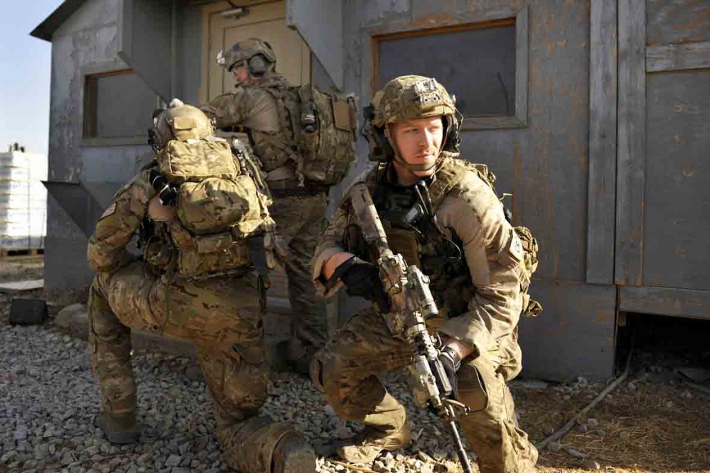 U.S. Air Force Capt. Cameron Rochelle, 83rd Expeditionary Rescue Squadron combat rescue officer, watches for potential threats as his teammates breech a door during a mission rehearsal in an excess structure here Aug. 26, 2014. The event allowed PJs to hone their breaching, clearing, patient care and egress skills. Air Force rescue forces conduct combat search and rescue and personnel recovery operations. Rochelle is deployed from Davis-Monthan Air Force Base, Ariz. The 83rd ERQS partnered with Joint Task Force Trailblazer, U.S. Army 2nd Engineer Brigade, to use the structure prior to its scheduled deconstruction. Task Force Trailblazer is currently demolishing 50-70 wooden structures here each week as part of Operation Enduring Freedom retrograde operations. (U.S. Air Force photo by Maj. Brandon Lingle/Released)