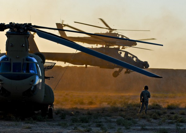 CAMP TAJI, Iraq  Sgt. Tyler Woodworth, Chinook helicopter crew chief, Company B, 2nd Battalion, 4th Aviation Regiment, Combat Aviation Brigade, 4th Infantry Division, Multi-National Division  Baghdad, watches as two Apache attack helicopters takeoff after being refueled by a Extended Range Fuel System II integrated Chinook cargo helicopter during a training exercise at Camp Taji Nov. 10. Soldiers from the 2nd Bn., 4th Avn. Regt., trained on the new mobile refueling system, respectively called "Fat Cow," to enable both forward-deployed air and ground assets to conveniently receive fuel directly from a Chinook integrated with a the crash resistant internal 2,400 gallon ERFS II. Woodworth is a native of Missoula, Mo. (U.S. Army photo by Sgt. Jason Dangel, CAB PAO, 4th Inf. Div.)