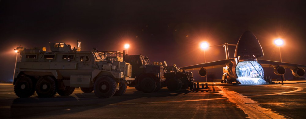 Airmen from the 9th Airlift Squadron and 455th Expeditionary Aerial Port Squadron with Marines from the Marine Expeditionary Brigade prepare to load vehicles into a C-5M Super Galaxy Oct. 6, 2014, at Camp Bastion, Afghanistan. Airmen and Marines loaded more than 266,000 pounds of cargo onto the C-5M as part of retrograde operations in Afghanistan. Aircrews for the retrograde operations, managed by the 385th Air Expeditionary Group Detachment 1, surpassed 11 million pounds of cargo transported in a 50-day period. During this time frame, crews under the 385th AEG broke Air Mobility Command’s operational cargo load record five times. The heaviest load to date is 280,880 pounds. (U.S. Air Force photo by Staff Sgt. Jeremy Bowcock)