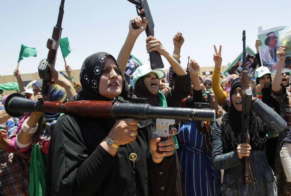 File foto diambil Selasa 28 Juni 2011 diambil pada tur terorganisir pemerintah, perempuan Libya menyebut slogan-slogan pro-Moammar Gadhafi saat mereka menghadiri sesi pelatihan senjata di kota Bani Walid, sekitar 200 km (120 mil) selatan timur dari Tripoli, Libya.