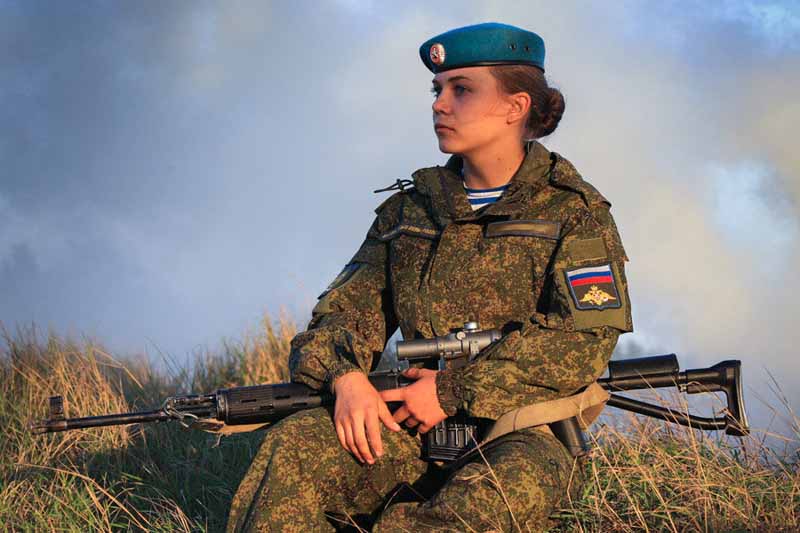 Female cadets of Russia's Ryazan Airborne School sits cradling her designated marksman rifle. 