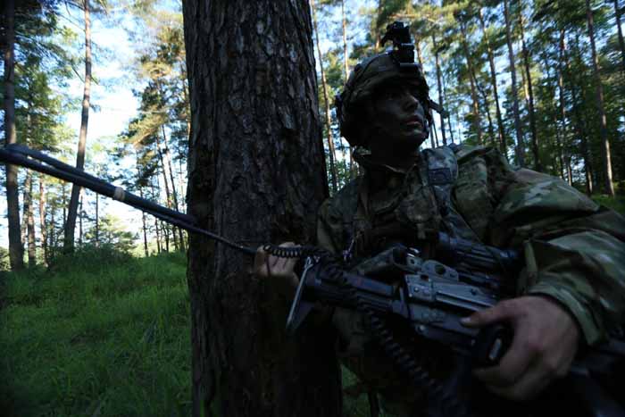 A US paratrooper radios higher command while conducting defensive operations.