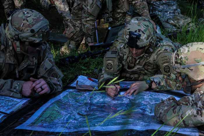  US soldiers locate a target on a map.