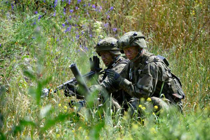 Multinational soldiers move toward their target.